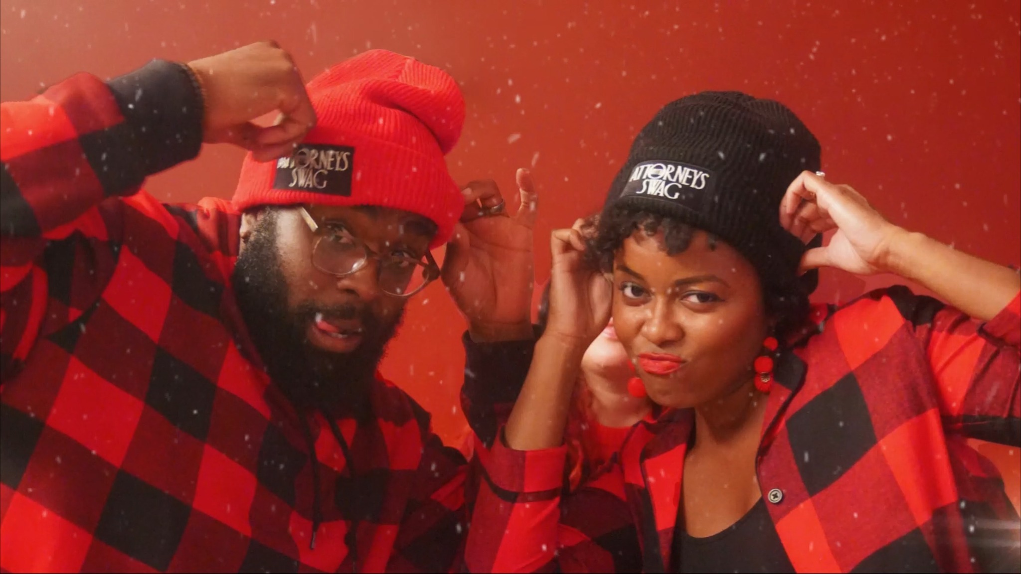 Two people wearing Attorneys with Swag knit hats in the holiday commercial
